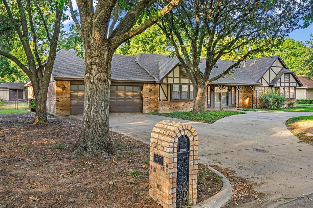 a front view of a house with a yard and tree s