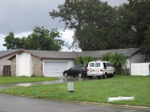 a front view of a house with a garden and parking space