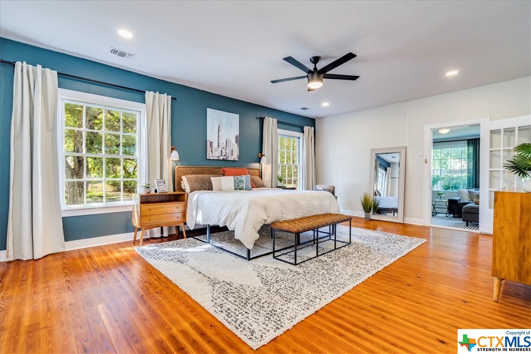 a bedroom with a bed rug and wooden floor