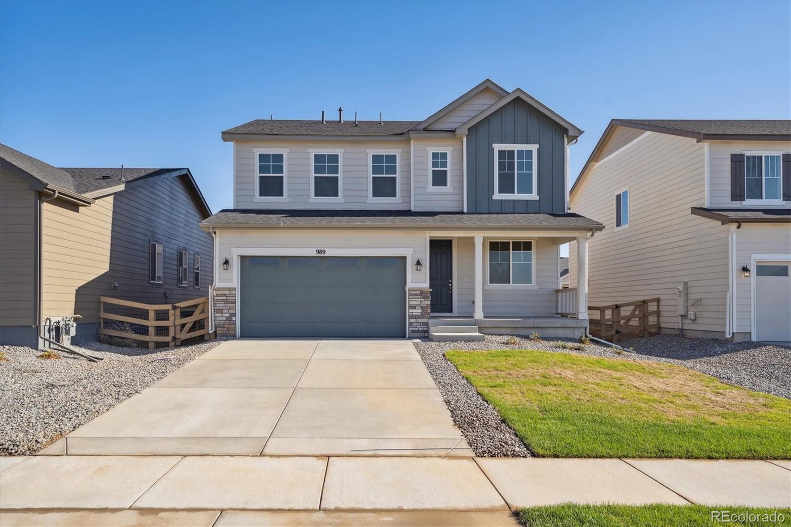 a front view of a house with yard and parking space