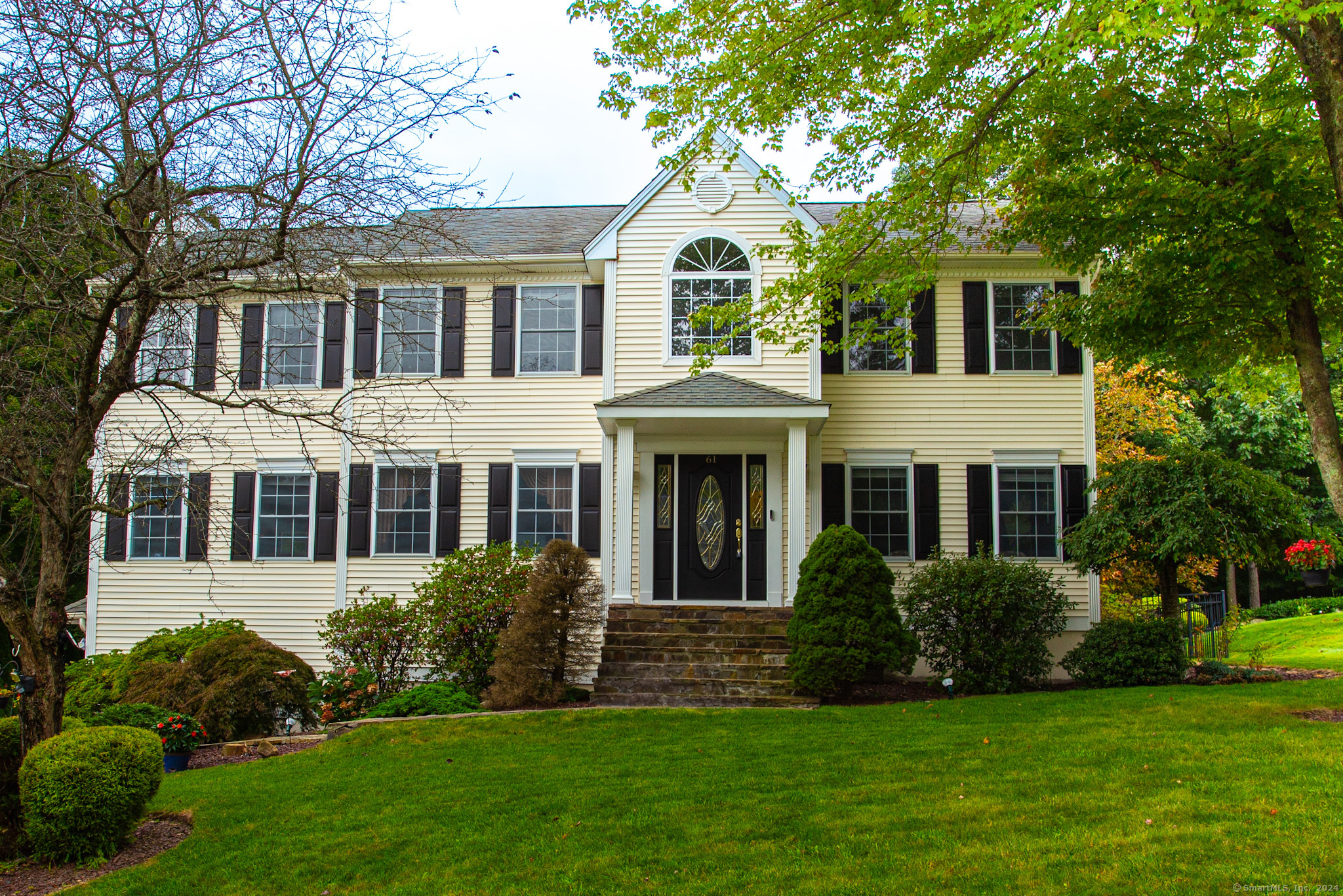 a front view of a house with a garden and yard