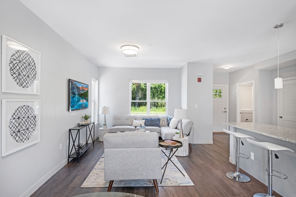 a living room with furniture wooden floor and window