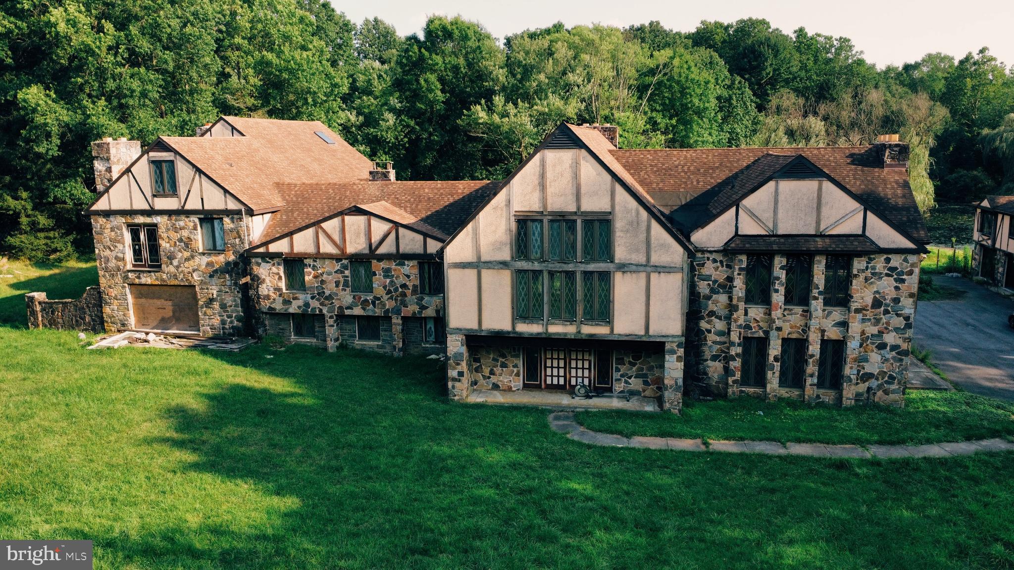 a view of a big house with a big yard and large trees