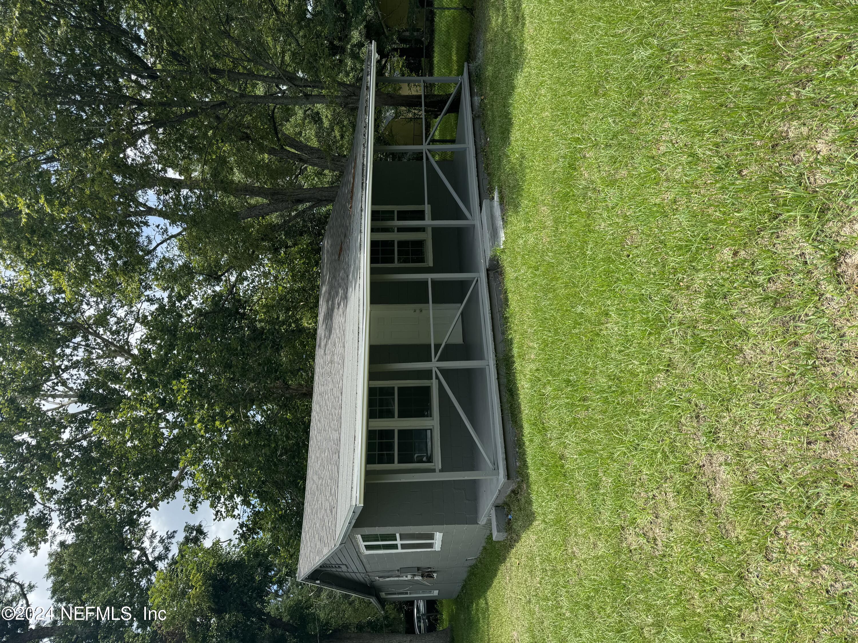 a view of an house with backyard space and balcony