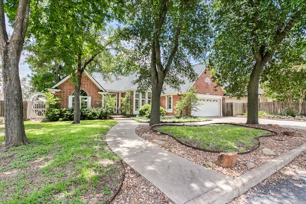 a front view of a house with a yard and trees