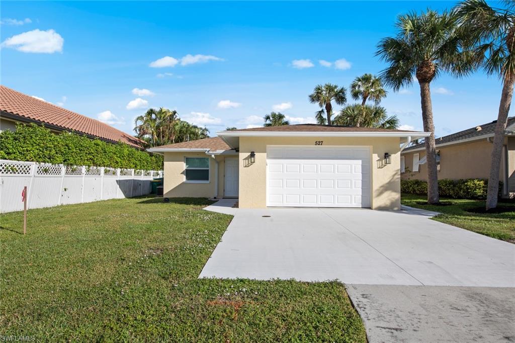 Single story home with a garage and a front yard