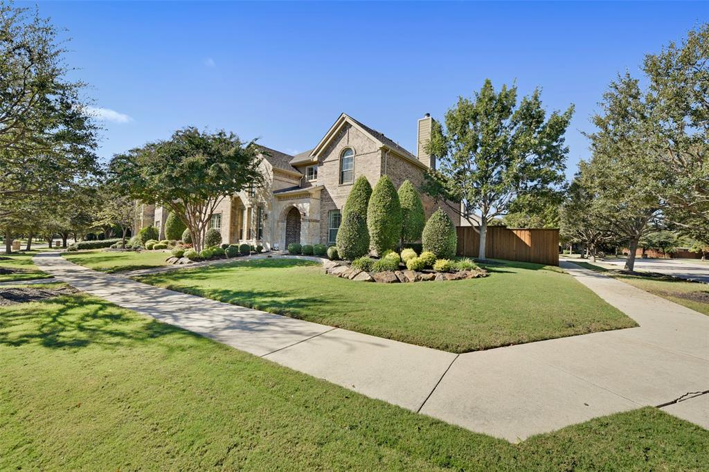 a front view of a house with a yard and trees