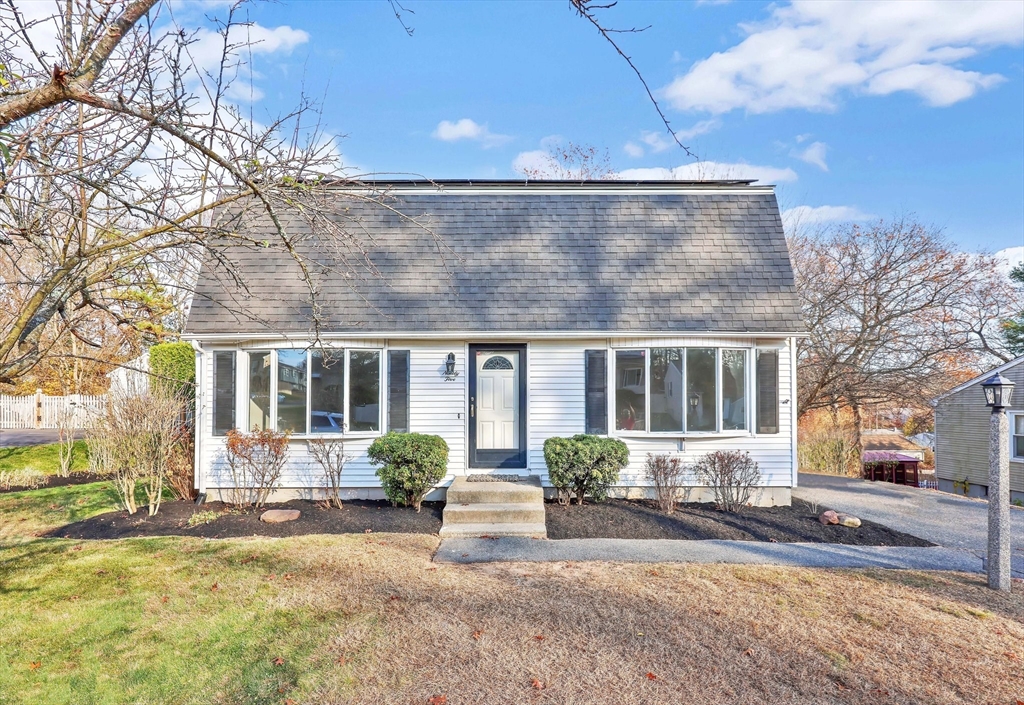 a front view of a house with a yard and potted plants