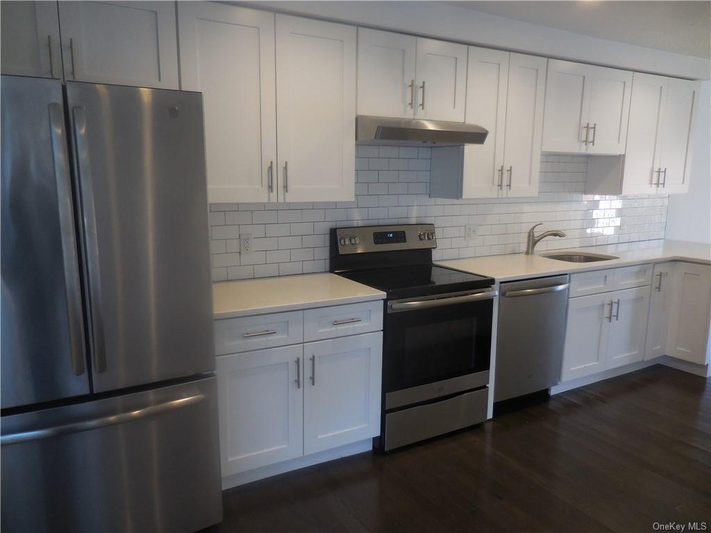 a kitchen with a refrigerator sink and cabinets