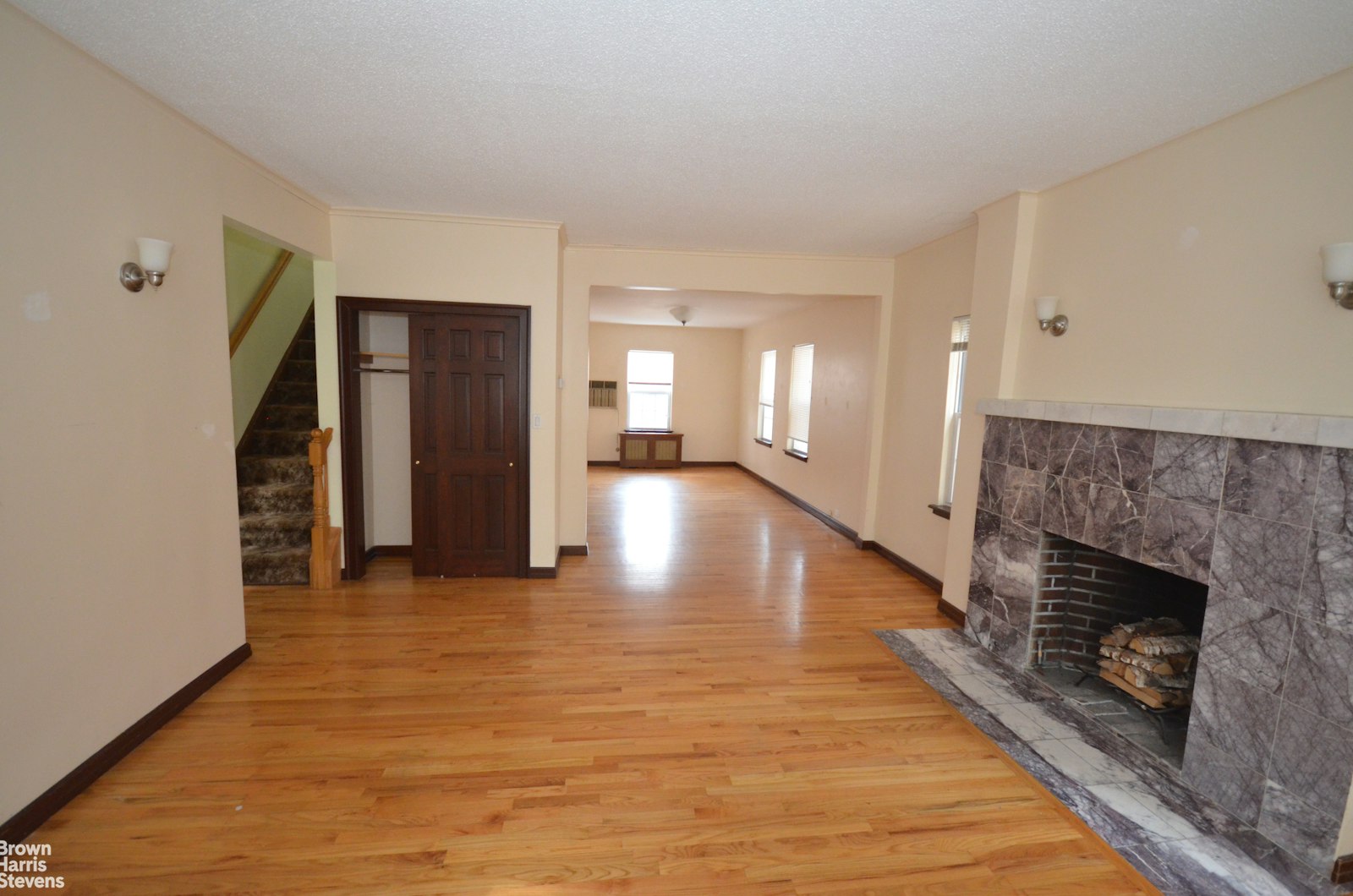 a view of a hallway with wooden floor and a fireplace