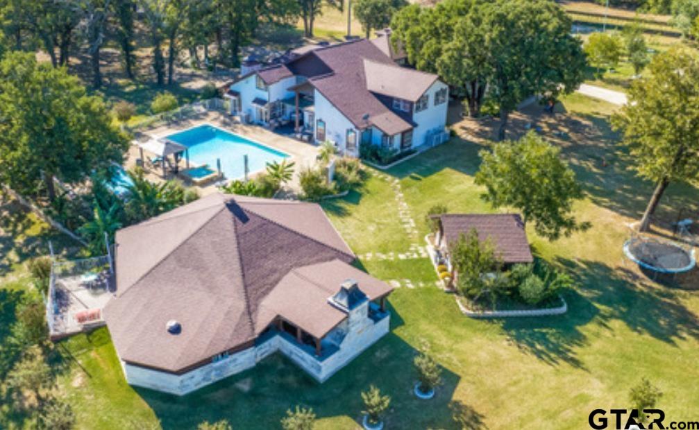 an aerial view of a house with a garden and lake view