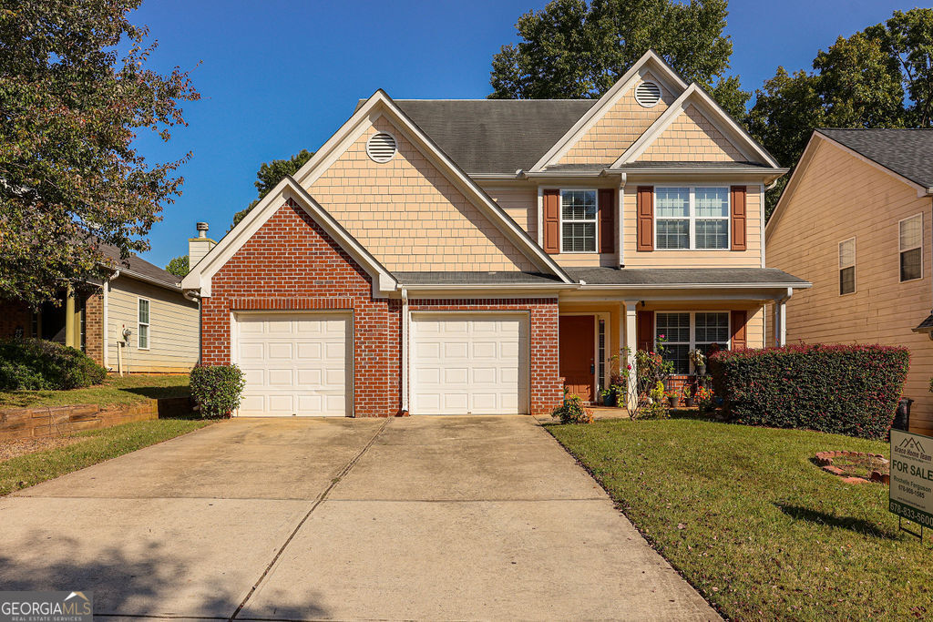 a front view of a house with a yard and garage