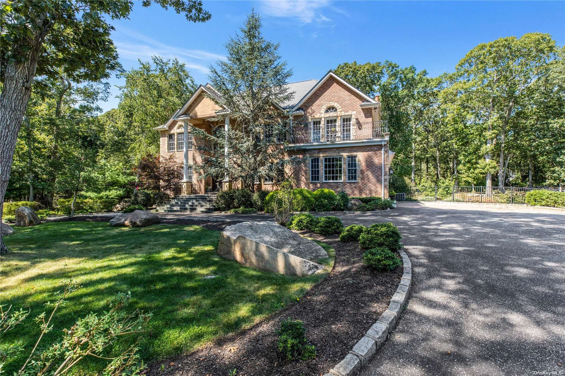 a front view of a house with a yard and shrubs