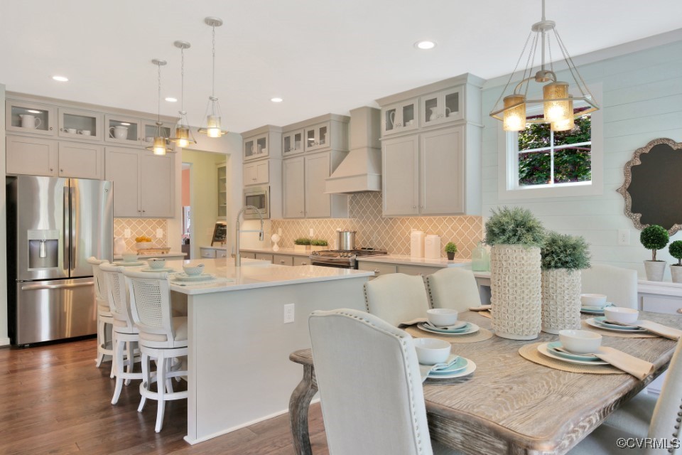 a kitchen with a table chairs refrigerator and microwave