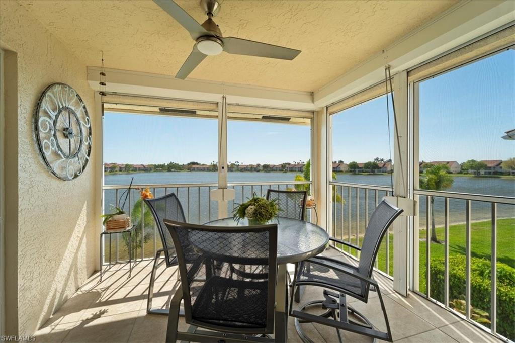 Sunroom / solarium with ceiling fan and a water view