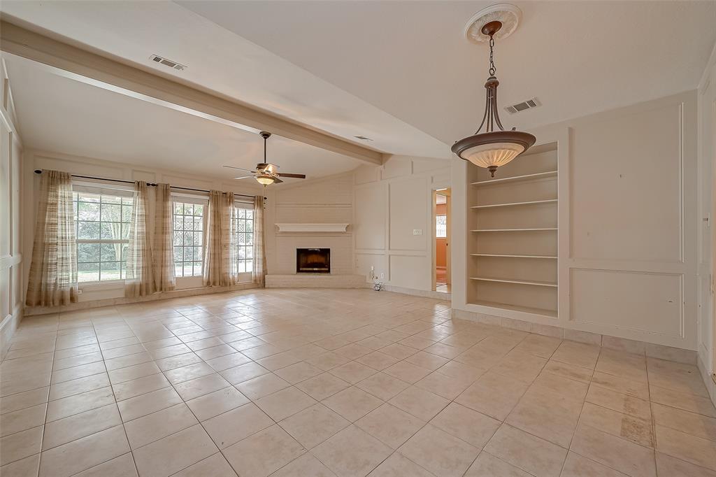 a view of empty room with windows and ceiling fan