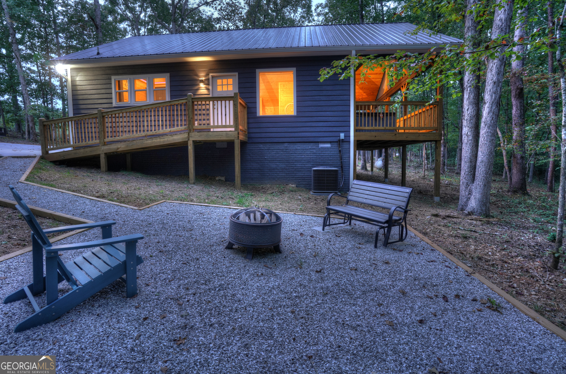 a view of a chairs and fire pit in the backyard