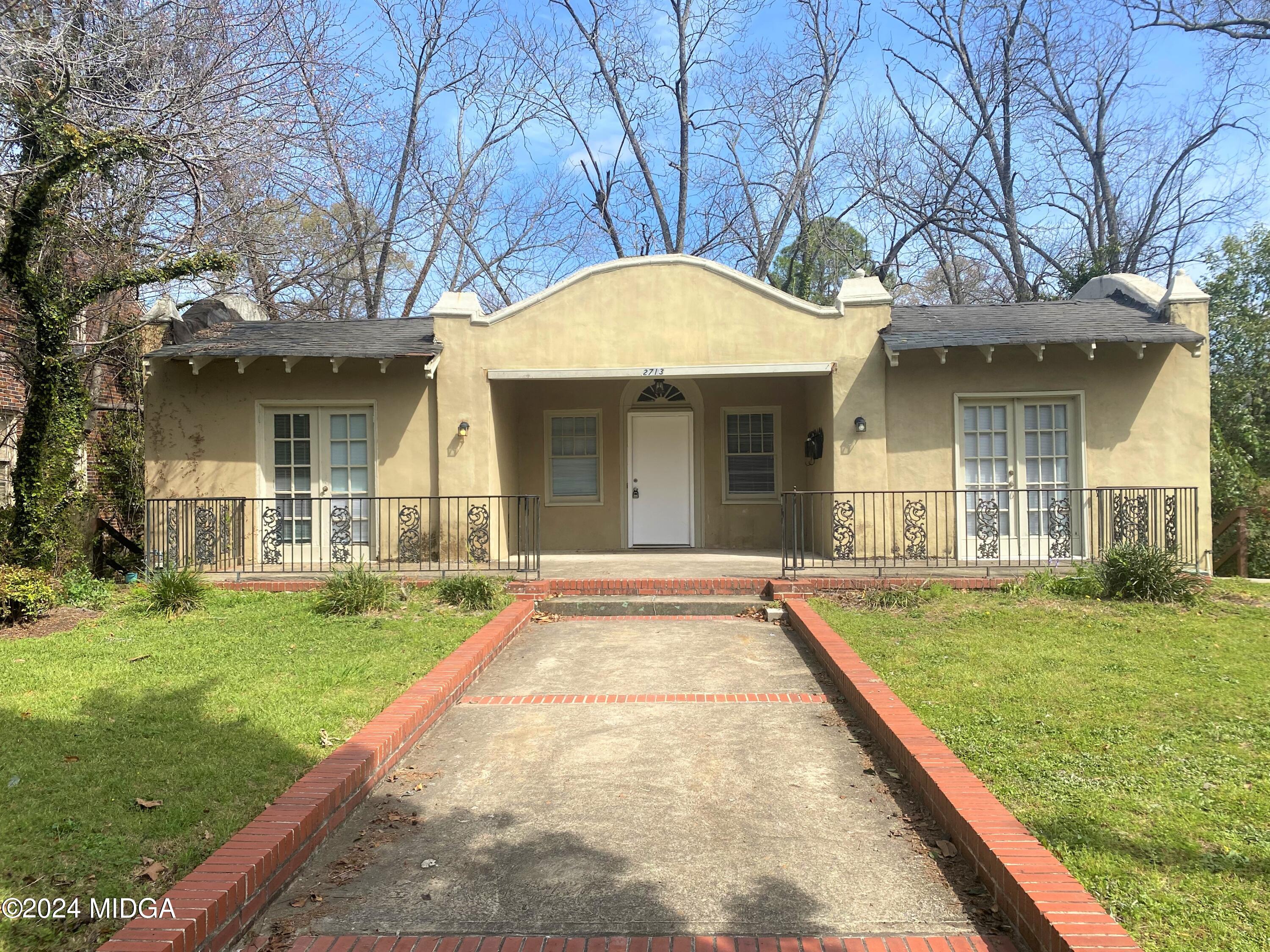 a view of a white house with a yard table and chairs