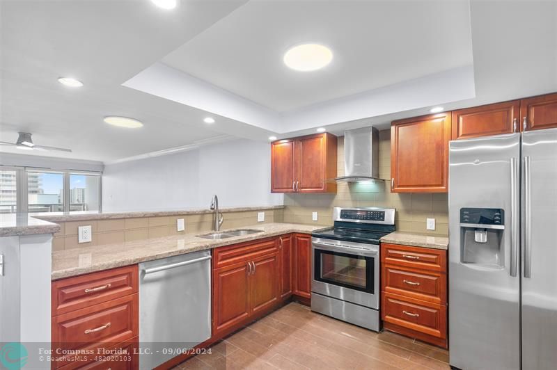 a kitchen with stainless steel appliances granite countertop a refrigerator sink and cabinets