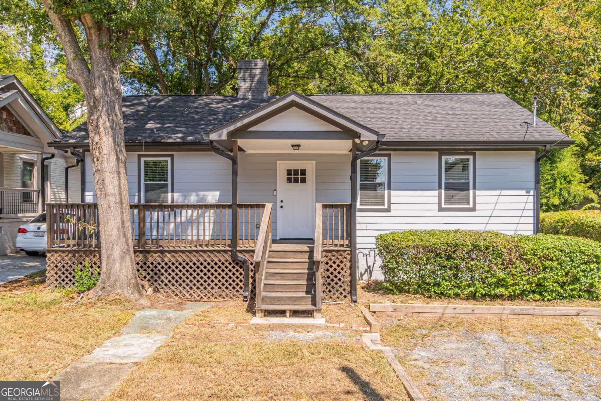 a view of a house with a small yard and wooden fence