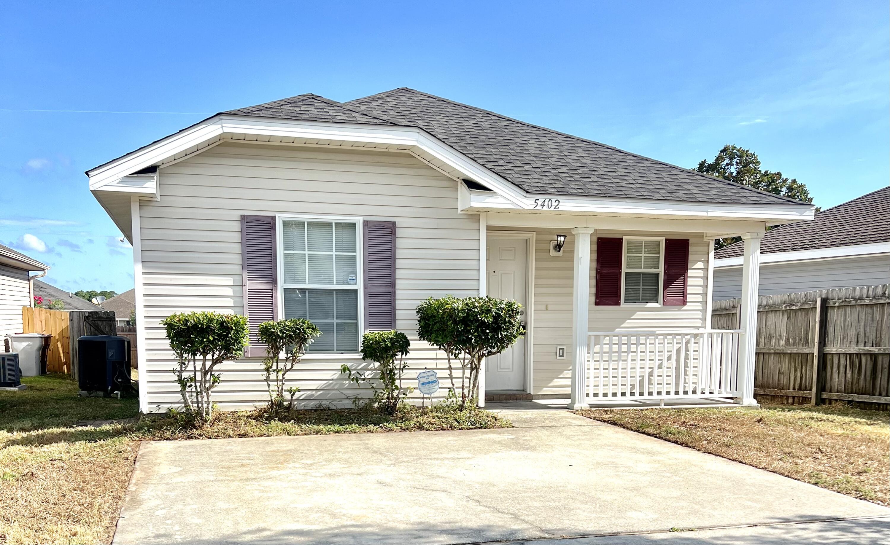 a front view of a house with yard and glass windows