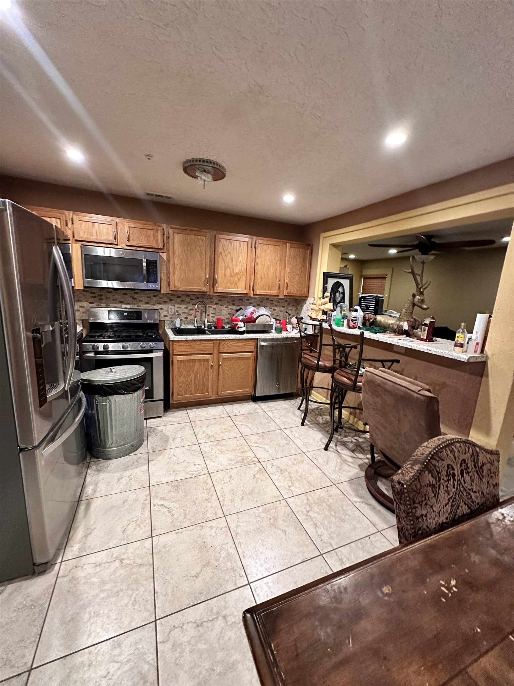 a kitchen with lots of appliances a sink a counter top space cabinets and stainless steel appliances