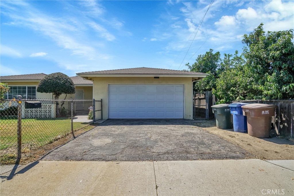 a view of backyard of house with wooden fence