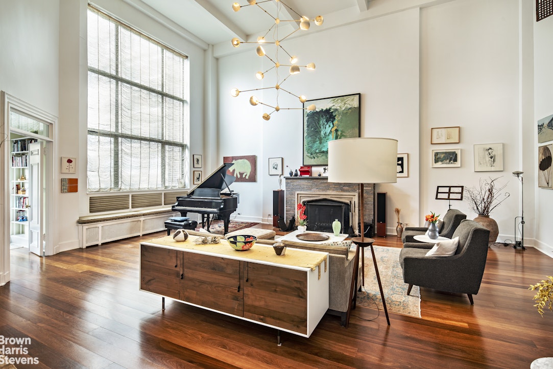 a living room with furniture fireplace and a large window