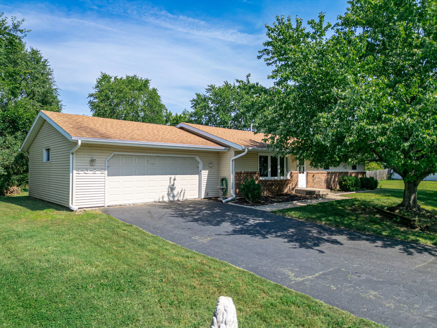 a front view of a house with a yard and trees