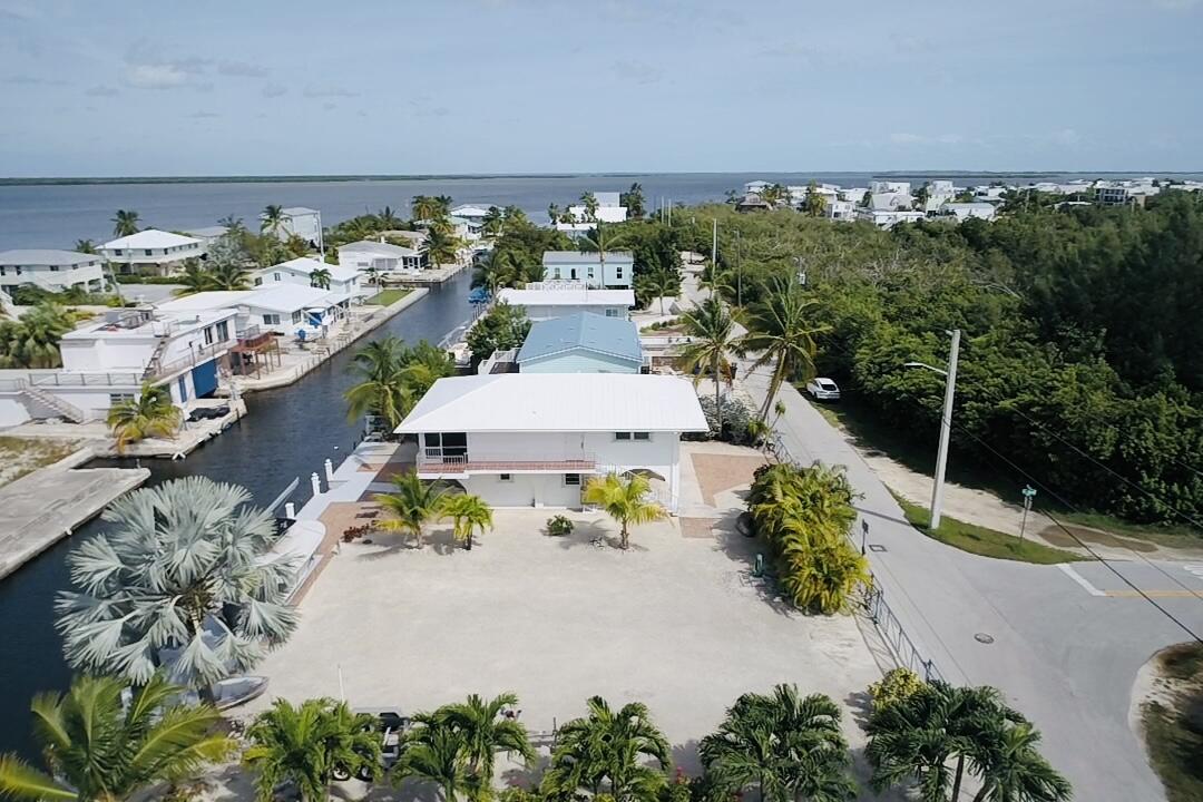 an aerial view of a house with a yard and lake view