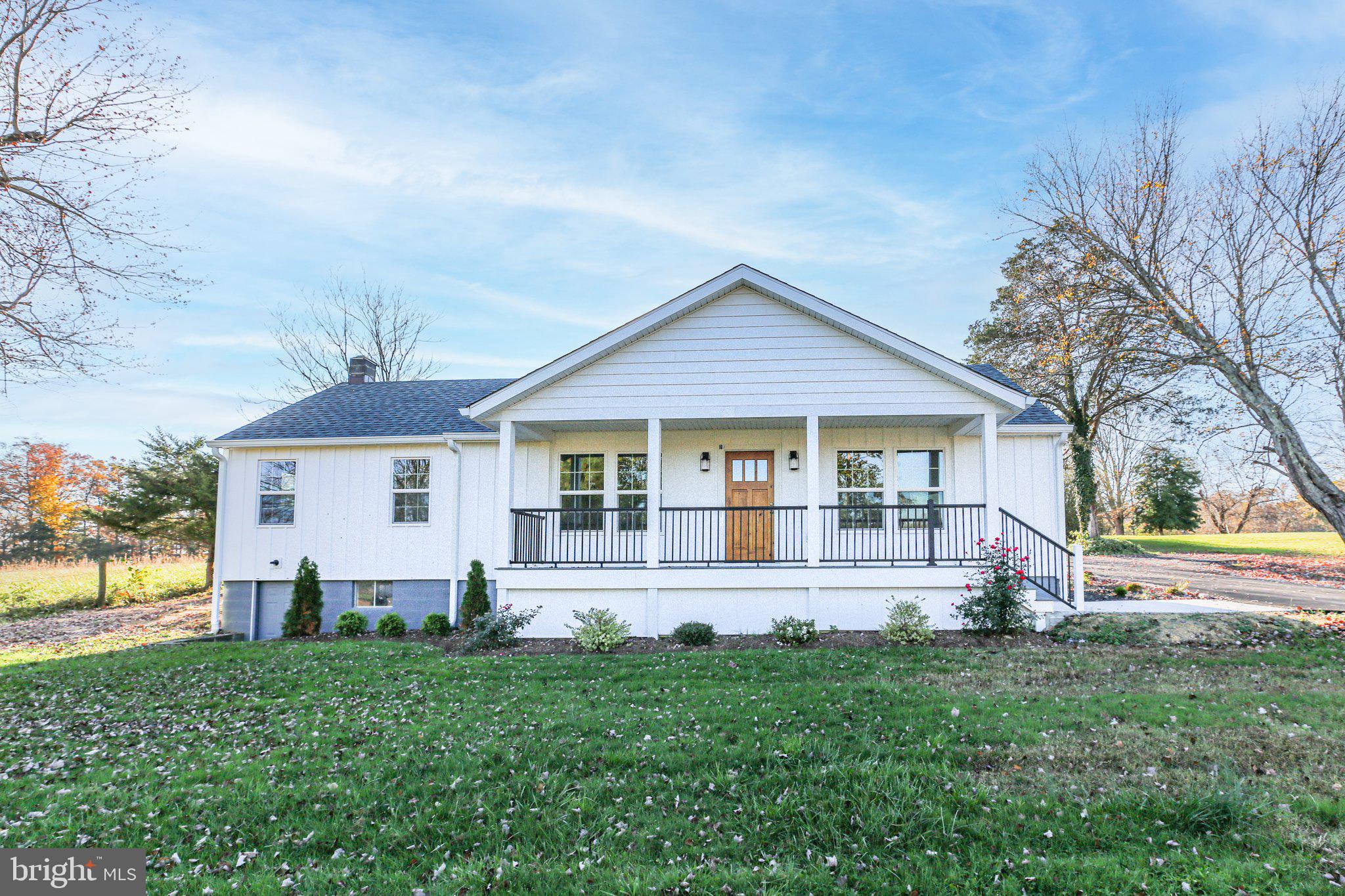 a front view of a house with yard and green space