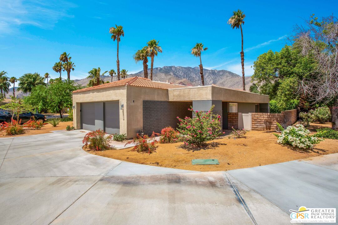 a view of a house with backyard and sitting area