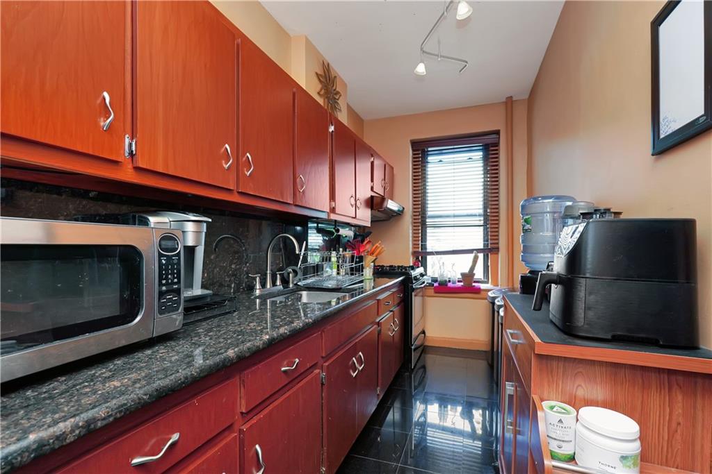 a kitchen with stainless steel appliances granite countertop a sink stove and cabinets