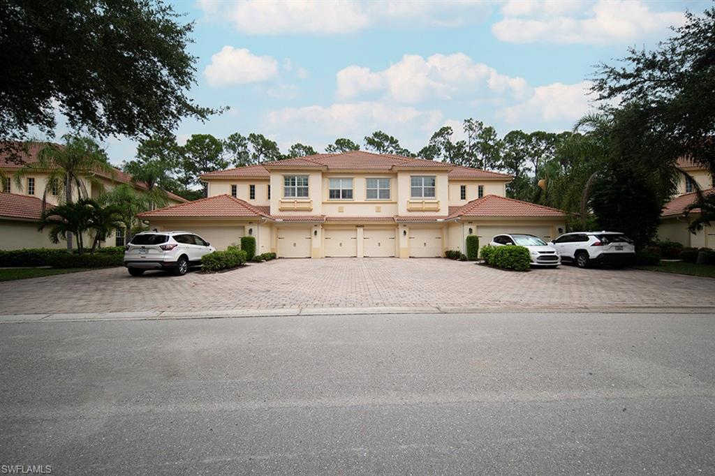 a front view of a house with a yard and a car parked in it