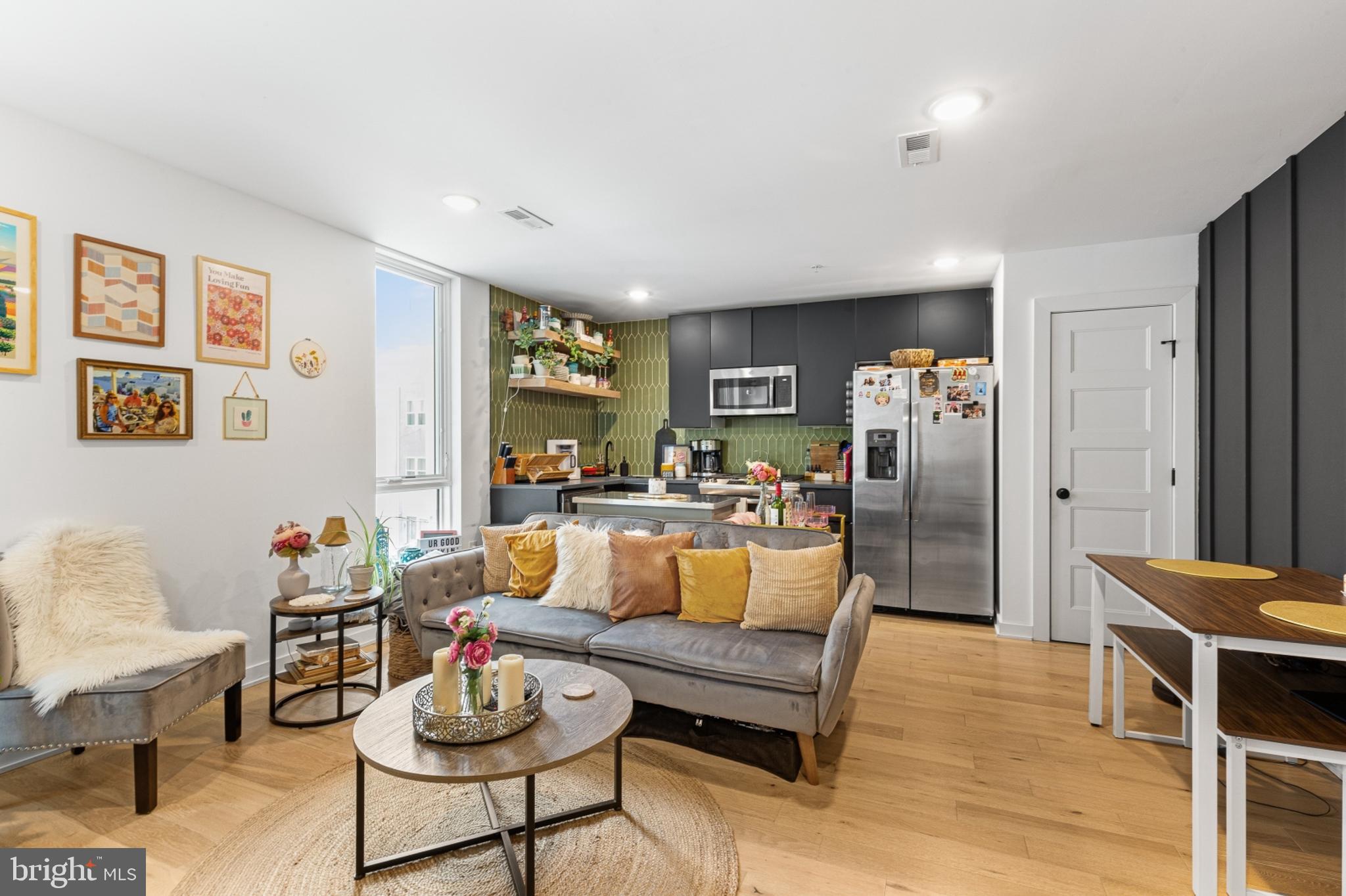 a living room with furniture kitchen view and a window