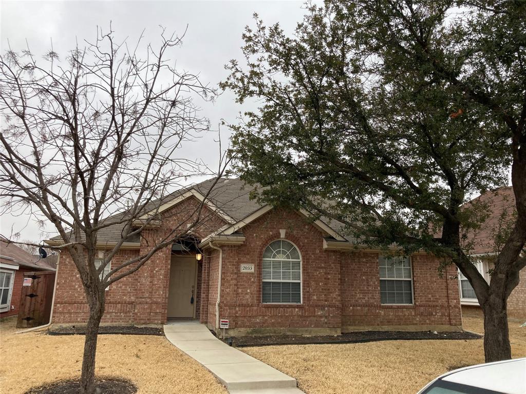 a front view of a house with a tree