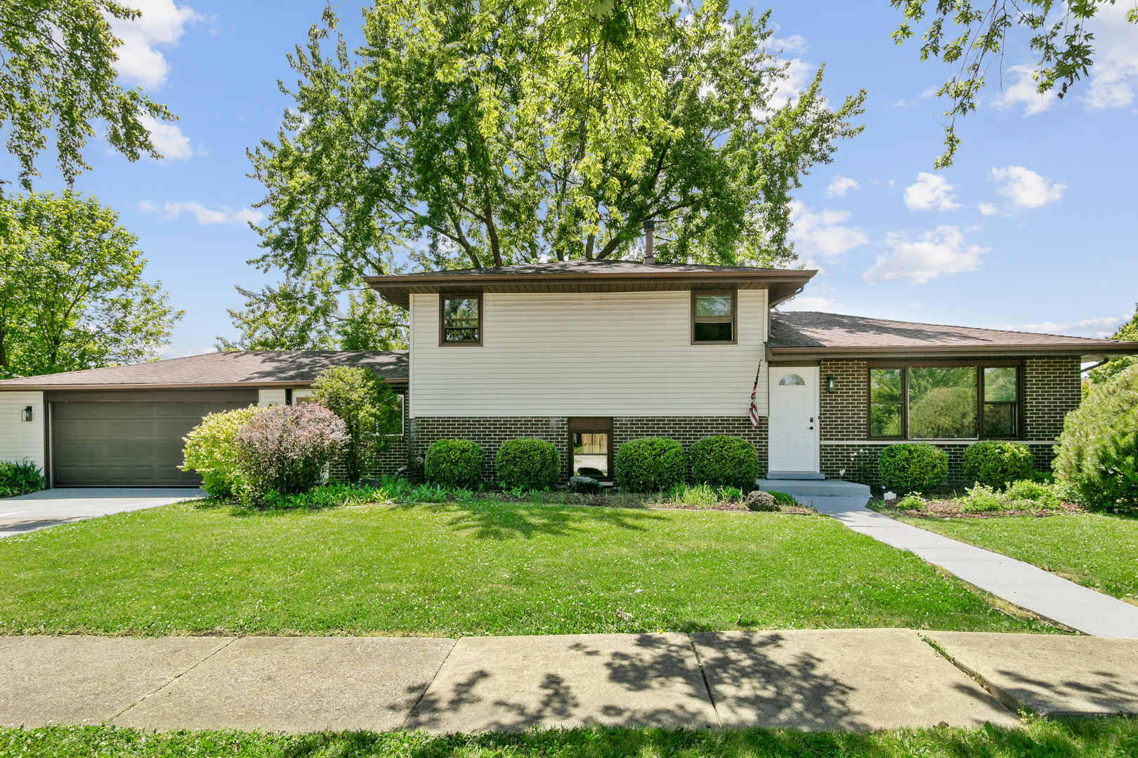 a view of a house with a yard and potted plants