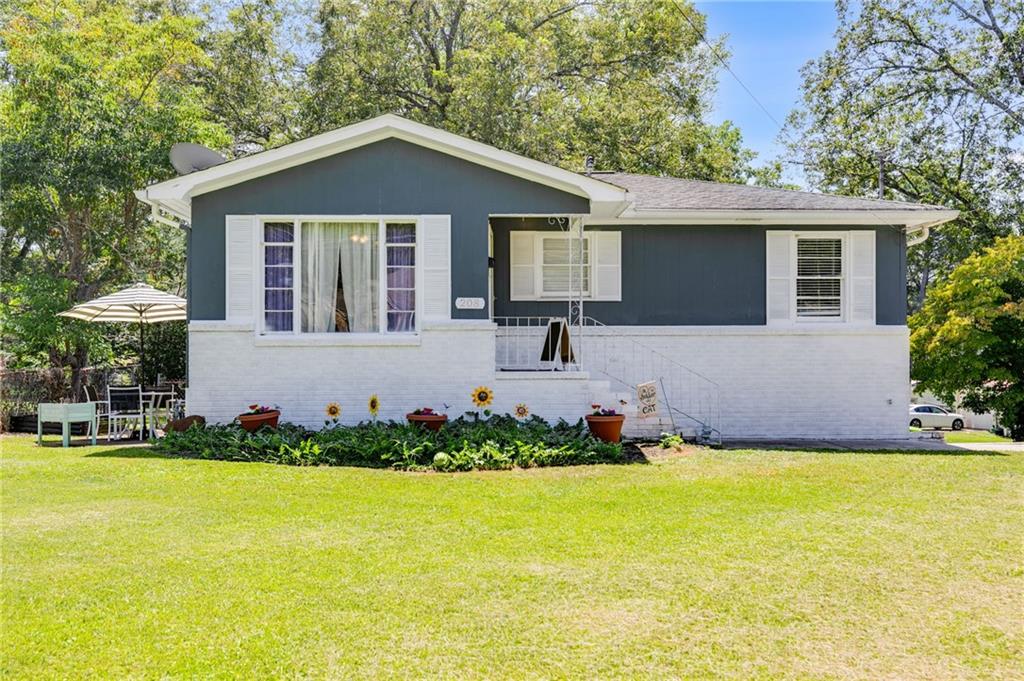 a front view of house with yard and trees in the background