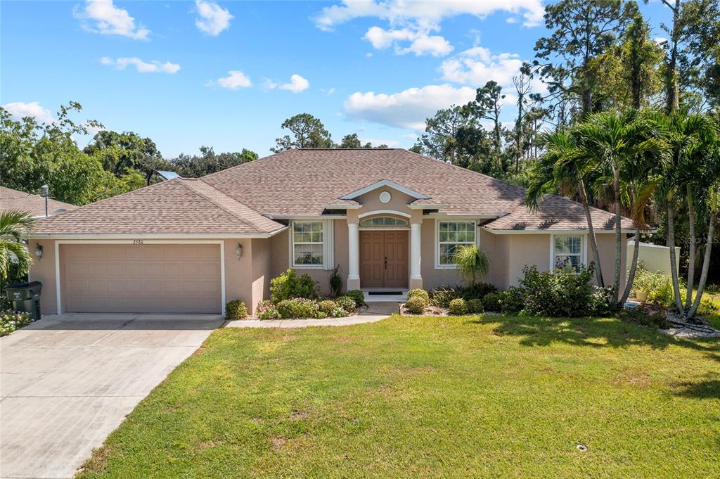 a front view of house with yard and trees around