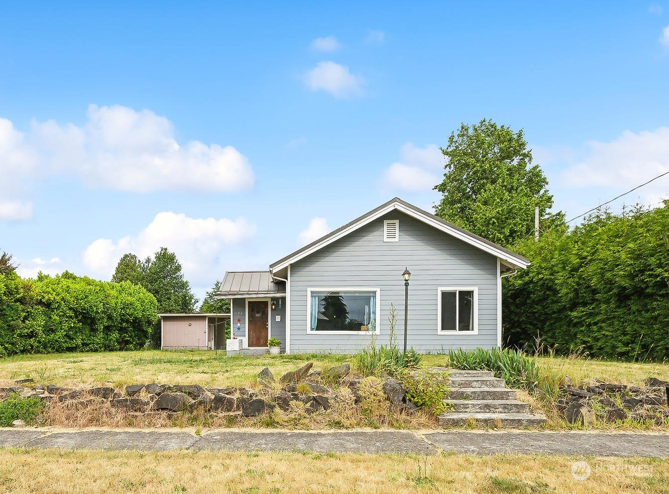 a view of a house with big yard and a large tree