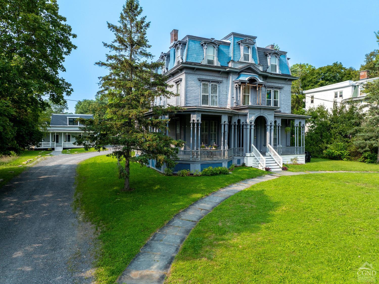 a front view of a house with a yard and green space