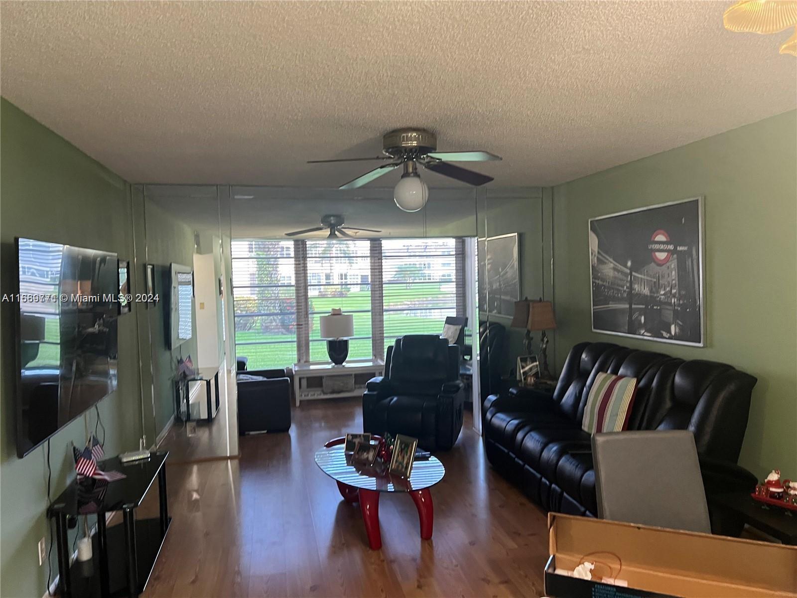 a living room with furniture flat screen tv and a large window