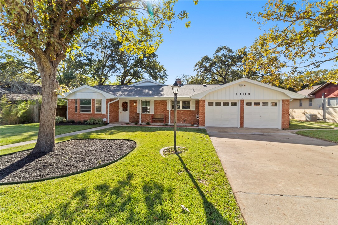 Ranch-style house with a garage and a front lawn