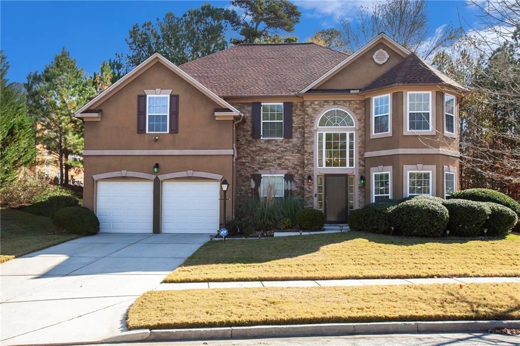 a front view of a house with a yard and garage