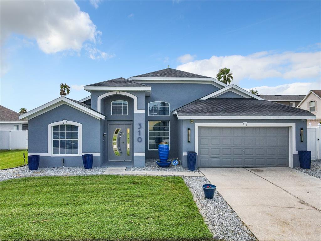 a front view of a house with a yard and garage