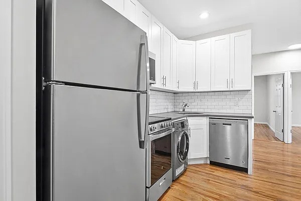 a kitchen with a refrigerator sink and stove top oven