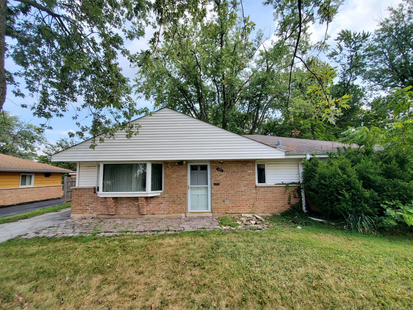 a front view of house with yard and trees