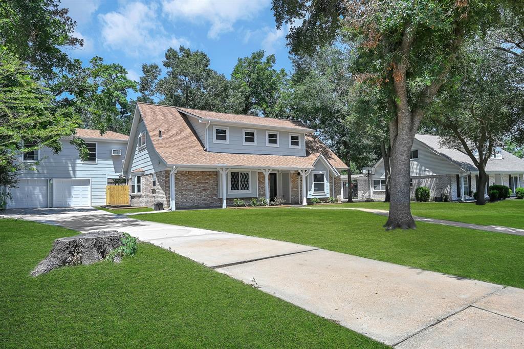 a front view of a house with a garden and trees