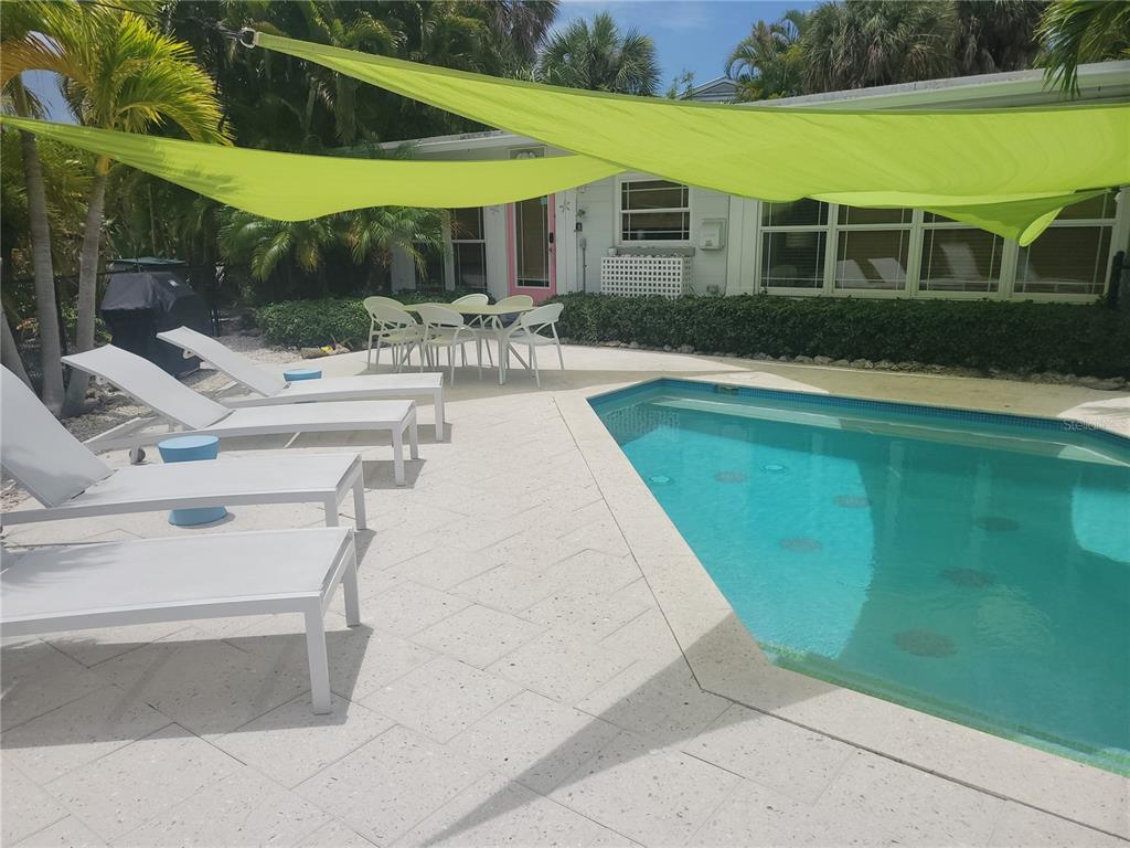 a swimming pool with outdoor seating and yard