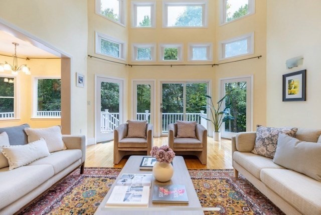 a living room with furniture wooden floor and a large window